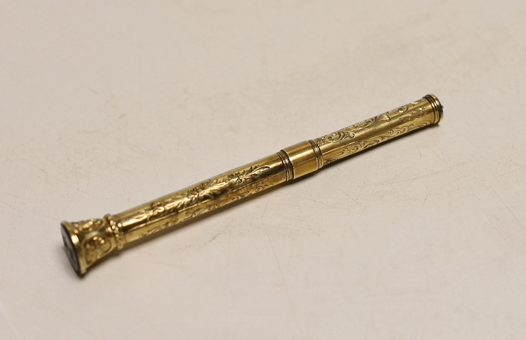 A late Victorian engraved yellow metal overlaid propelling pen and pencil, with bloodstone set terminal, 95mm.
